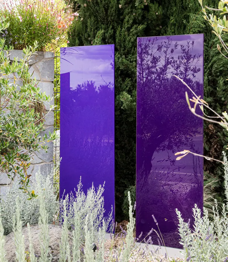 Violette Glasstelen zwischen Säulenzypressen, Lavendel und Silberlaub